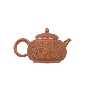 Jianshui zitao red clay teapot featuring dense needle-textured surface, side view.