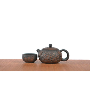  Handcrafted Jianshui zitao teapot featuring an all-over hand-carved lotus pattern, displayed with a matching cup