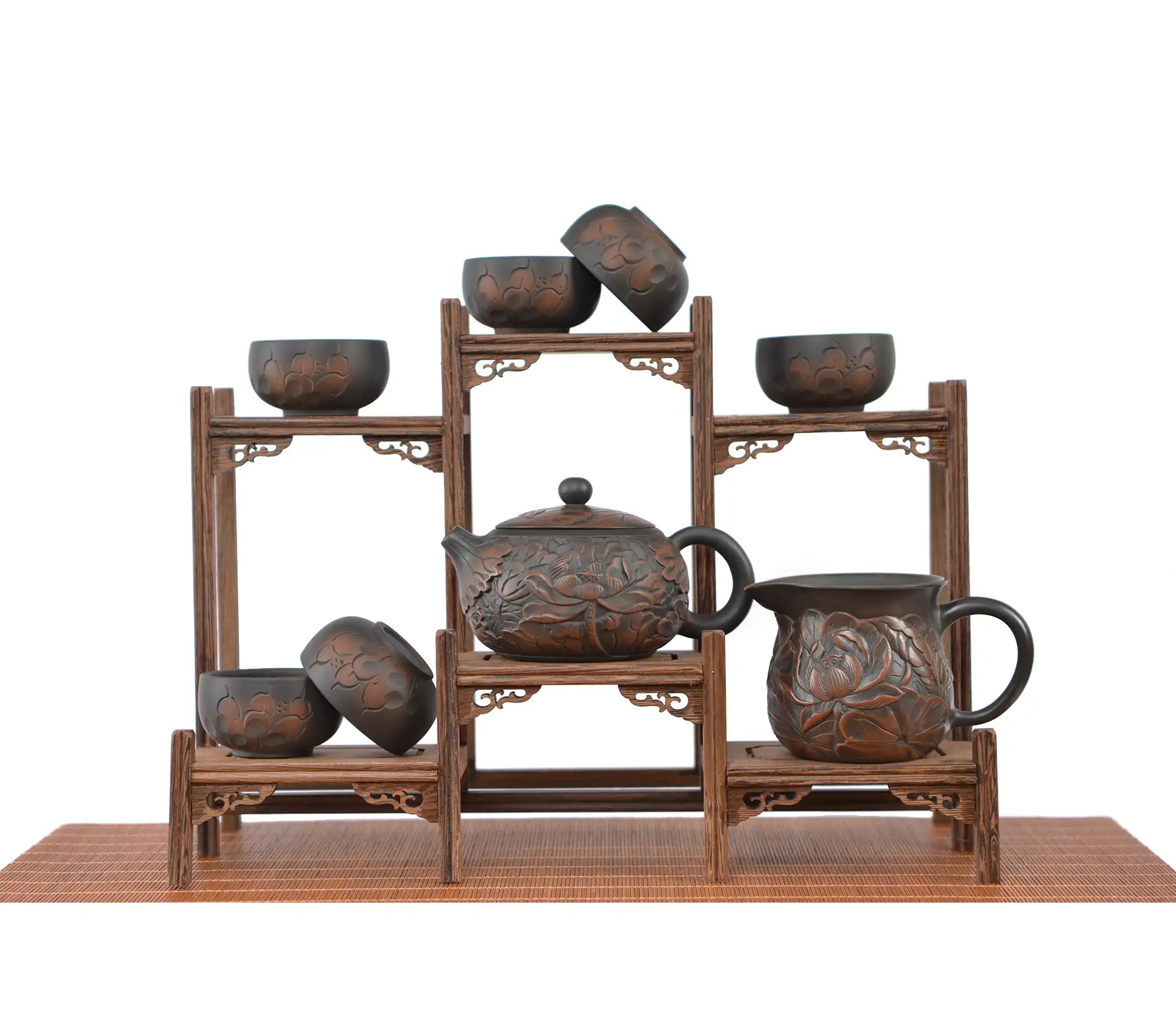 Jianshui zitao tea set with fully carved lotus design, displayed on a tiered wooden stand with teapot, fairness pitcher, and tea cups