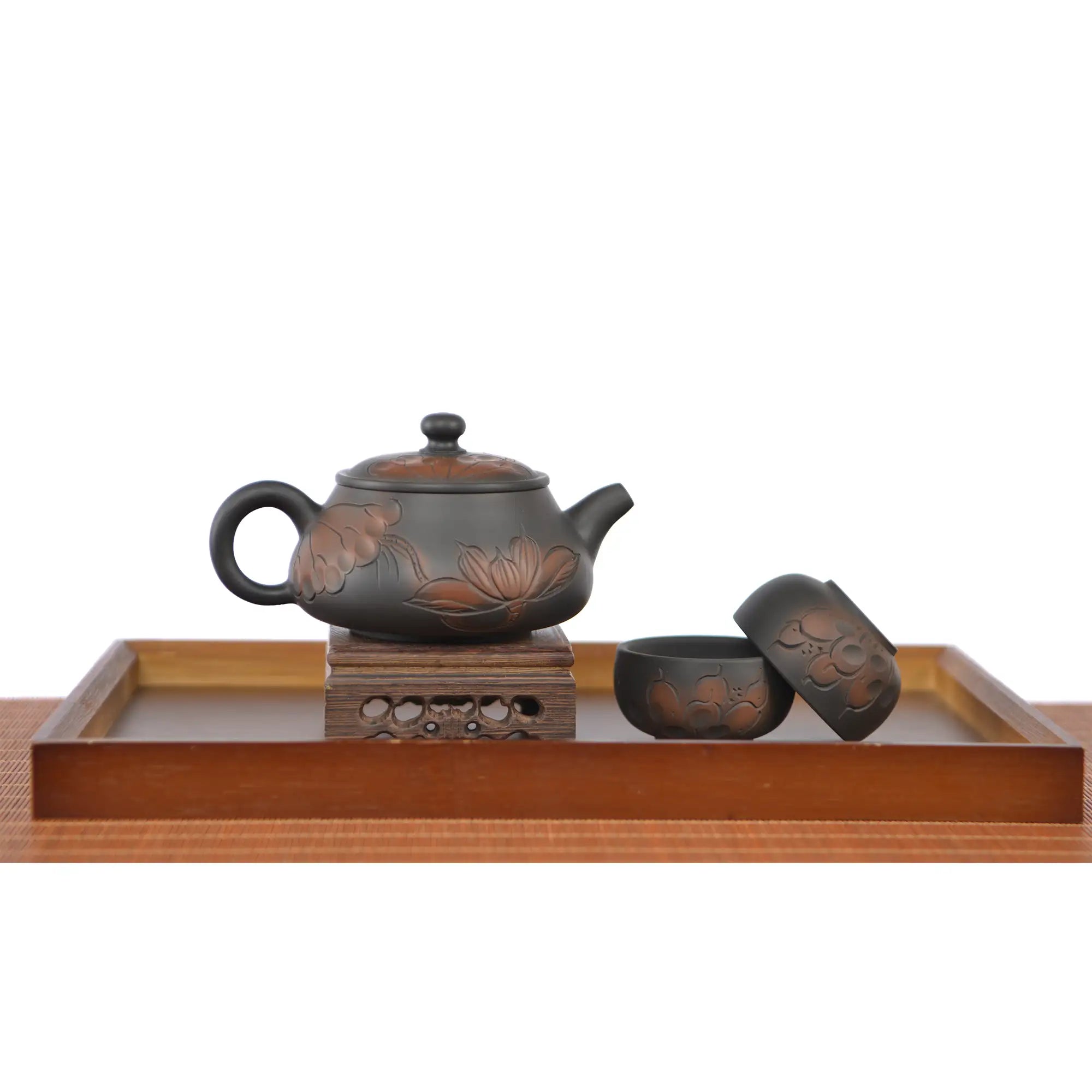 Handmade pottery Shi Piao teapot with a line-carved lotus design, displayed with two matching tea cups.