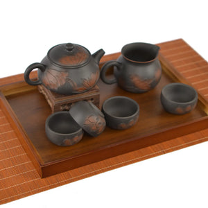 Complete handmade pottery tea set featuring a line-carved lotus Shi Piao teapot, four matching cups, and fairness pitcher.