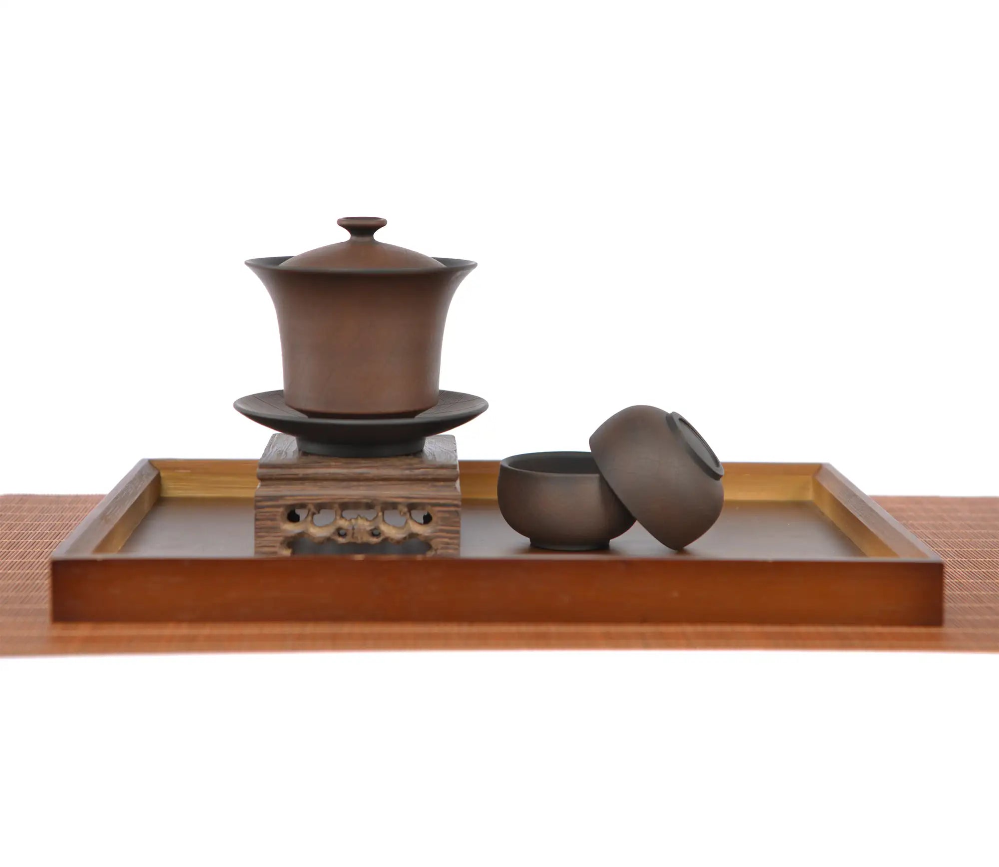 Warm brown bodhi-pattern pottery gaiwan with matching saucer, displayed on a wooden stand with two small teacups and lid on a tea tray
