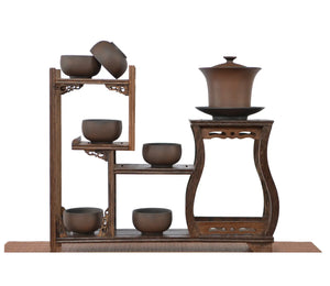 Warm brown Bodhi-pattern pottery gaiwan with six matching teacups displayed on a multi-tier carved wooden stand, showing the textured unglazed finish and harmonious tea set arrangement