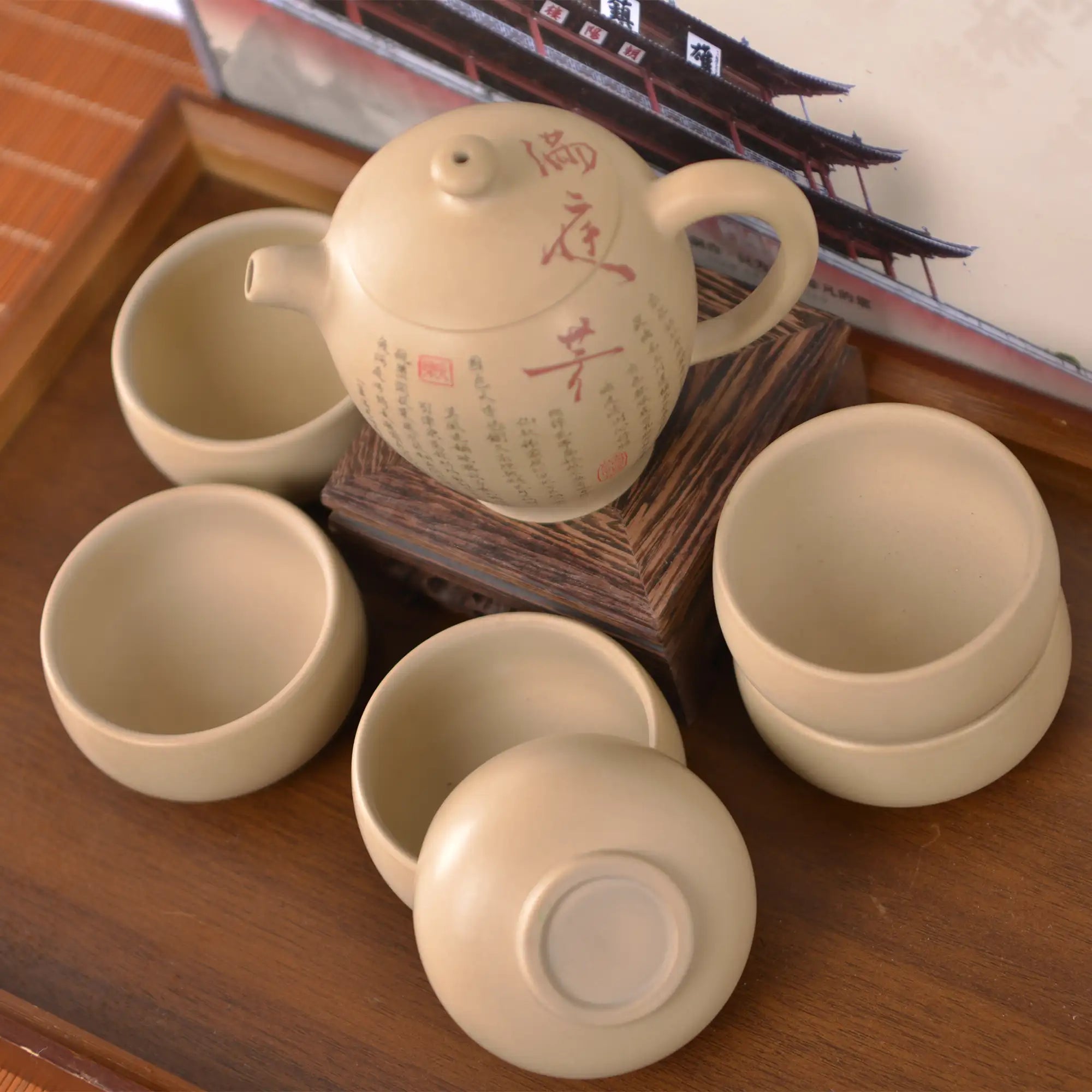 Top view of a handcrafted white clay peony teapot set with six matching cups, featuring hand-carved calligraphy details.