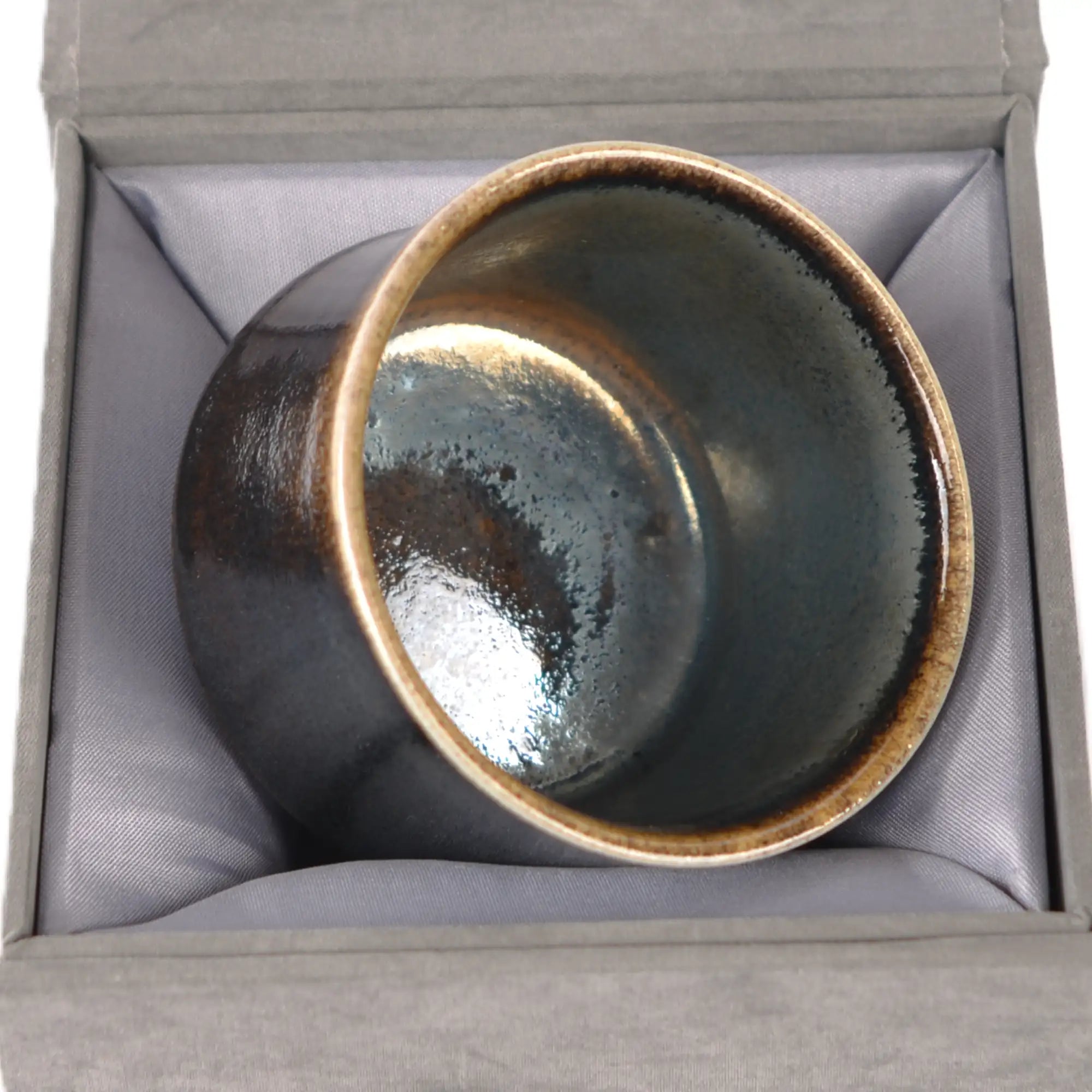 Jianshui zitao wood-fired cup displayed on a gift box, emphasizing its one-of-a-kind kiln-fired character