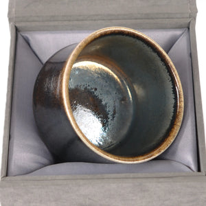 Jianshui zitao wood-fired cup displayed on a gift box, emphasizing its one-of-a-kind kiln-fired character