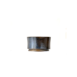 Jianshui zitao wood-fired cup showing deep tonal shading shaped by prolonged flame exposure, side view