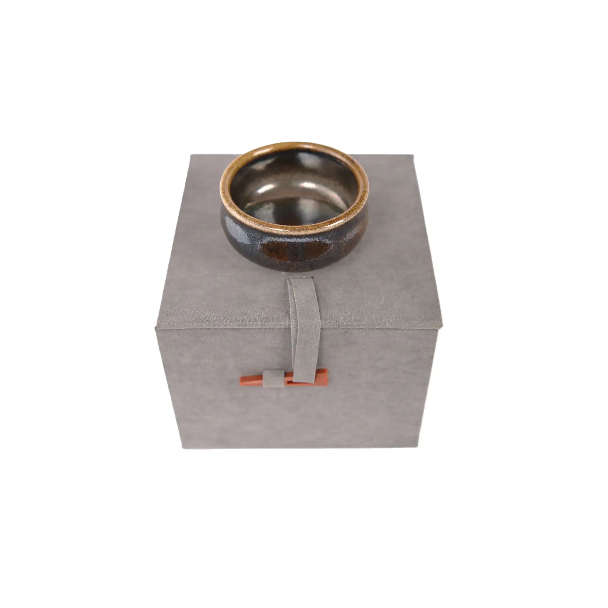 Jianshui zitao wood-fired cup displayed on box, highlighting natural ash glaze variations.